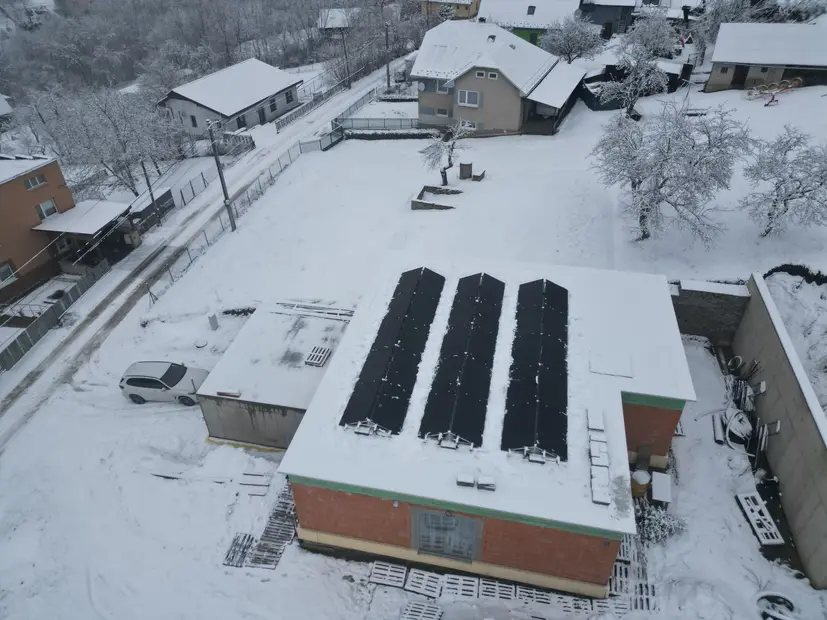 Tri rady panelov na streche haly, zimný záber z dronu.